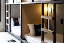 stylish industrial bunk beds of metal and wood, with wall lamps and ladders to reach each upper bed