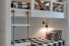 vintage rustic bunk beds with a rope ladder, wall lamps and stained wood railing for safety