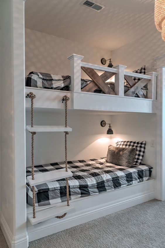 vintage rustic bunk beds with a rope ladder, wall lamps and stained wood railing for safety