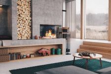 a bold and cool modern living room with a large concrete fireplace and a niche for storing firewood is very welcoming