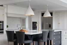 a bold contrasting kitchen with white shaker style cabinets, a black kitchen island with storage and black leather stools and pendant lamps