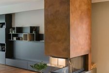 a contemporary fireplace with a concrete base, a metal hood and a glass cover looks contrasting and very bold
