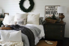 a cozy wintry bedroom with knit blankets, an evergreen wreath, a Christmas tree feels veyr cozy and chic