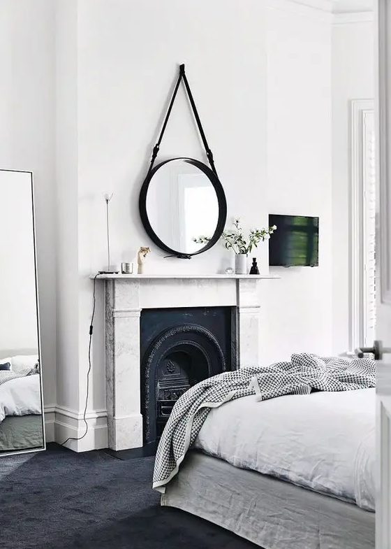 a fireplace as a centerpiece of the bedroom, done with wrought details and a chic stone mantel