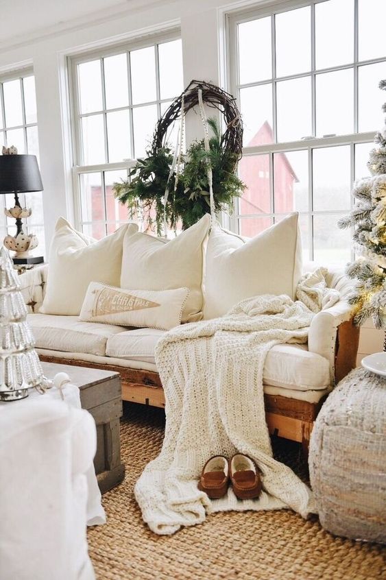 a knit blanket and lots of pillows plus a jute rug make the living room welcoming and cozy