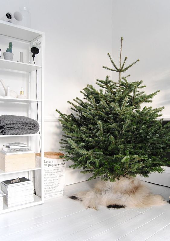 a minimalist Scandinavian Christmas tree with no decor and only faux fur to cover the base is a gorgeous idea to rock