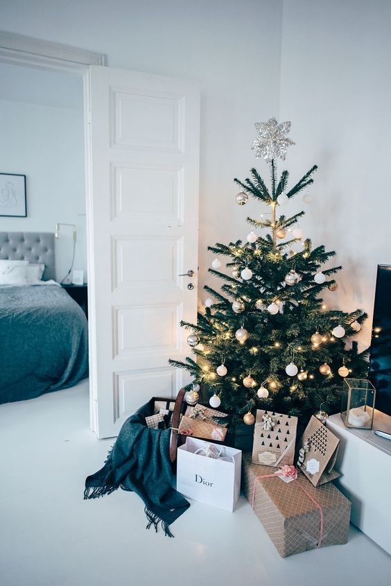 a modern Christmas tree with white and gold ornaments and plus lights and a silver star topper is a pretty and chic idea