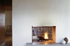 a modern white double-sided fireplace with a concrete stand is a cozying up and chic idea for a modern space