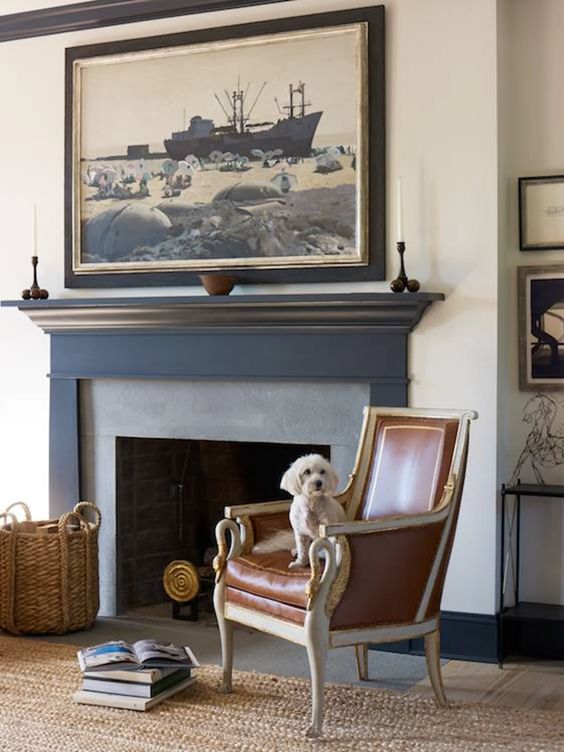 a sophisticated nook with a brick fireplace, a vintage chair and a statement artwork over the fire
