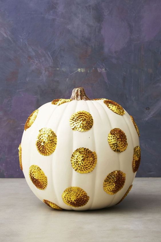a white pumpkin with large gold sequin polka dots will give a cool glam feel to your Thanksgiving decor