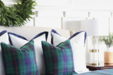 dark plaid bedding and a greenery wreath will easily transform your bedroom into a wintry space