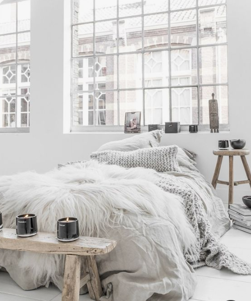 Faux fur, candles, bowls and a rough wooden bench plus a knit pillow are ideal for a winter like Scandinavian bedroom