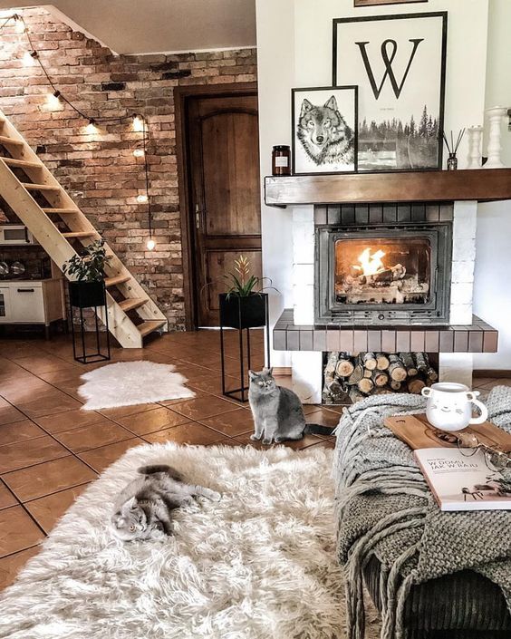 layered blankets and fur rugs make the living room very cozy, and the fireplace adds to the ambience