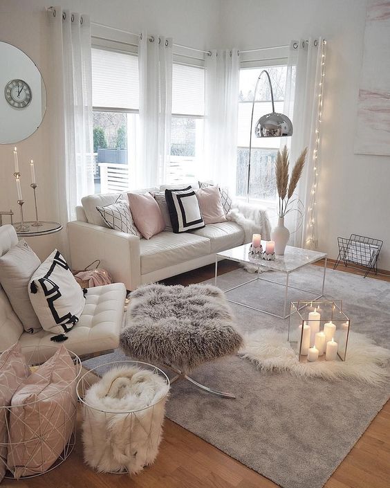 layered fur rugs, a fur stool and a fur blanket make the living room more welcoming and cozy