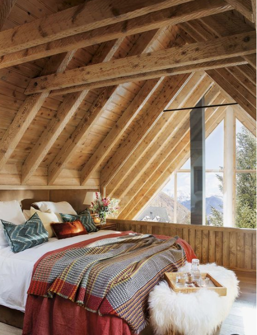 plaid and knit bedding and pillows, a faux fur ottoman make this cabin bedroom very chic and welcoming