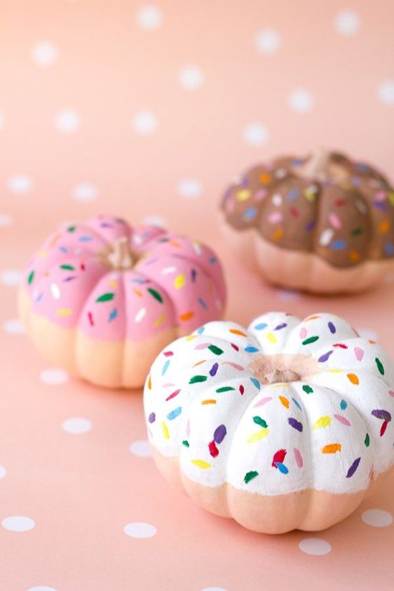 pumpkins painted as pretty donuts are a creative and delicious Thanksgiving decoration to try