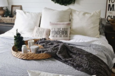 white and chocolate brown knit blankets, printed pillows, an evergreen wreath and a mini Christmas tree for a winter fele in the space