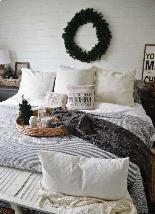 white and chocolate brown knit blankets, printed pillows, an evergreen wreath and a mini Christmas tree for a winter fele in the space