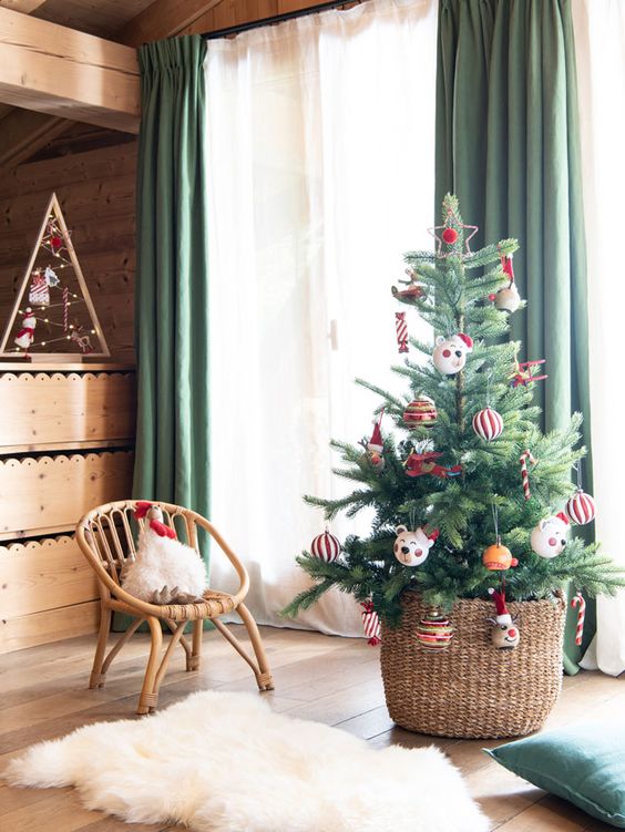 a Christmas tree in a basket with colorful and pretty ornaments is a lovely decoration for the holidays and it will look amazing always