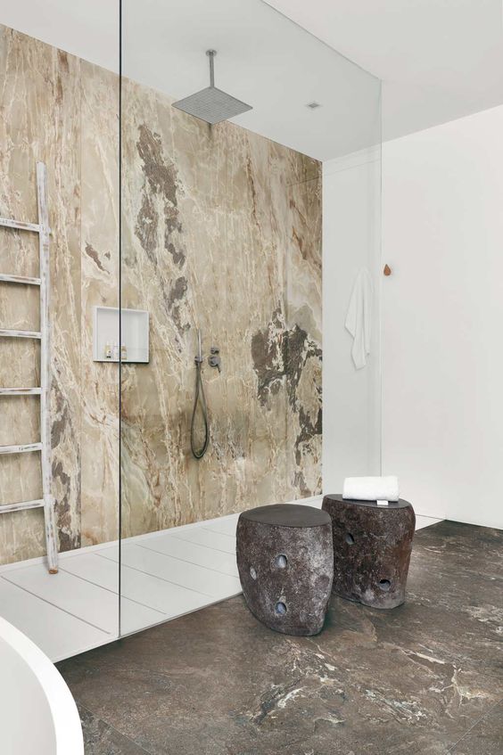 a beautiful minimalist bathroom with an onyx accent wall in the shower and an onyx floor of a different color outside it