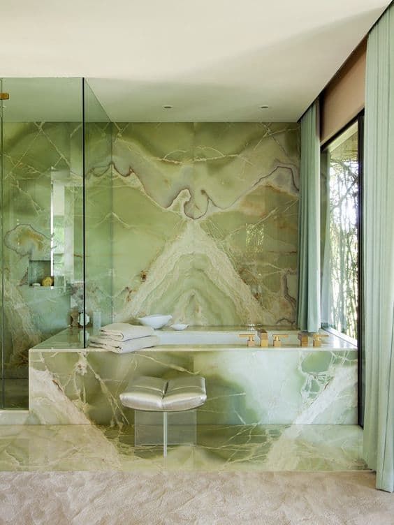 A fantastic green onyx bathroom with clear glass space dividers and a stool is a jac dropping idea for a luxury home