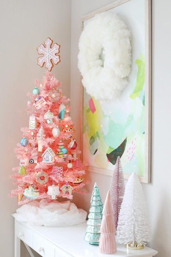 a hot pink Christmas tree with fun and whimsical ornaments and a cookie tree topper for creating a holiday feel in the space
