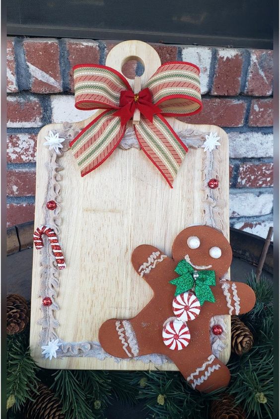 a pretty kitchen decoration with a cutting board, a bright bow, candy canes, a faux gingerbread man with peppermints and a bow
