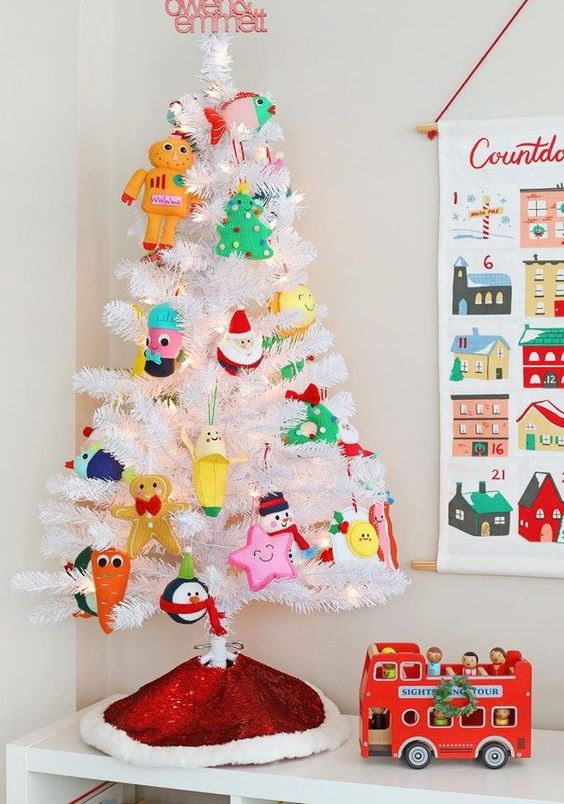 a white Christmas tree with lights and funny colorful ornaments is an easy and fun way to add a holiday feel to the room