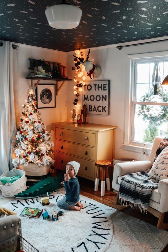 a white Christmas tree with lights and red and green ornaments, a deer head with lights will bring a strong festive feel to the space
