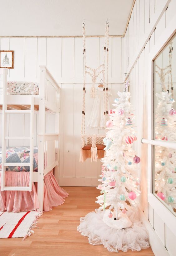 a white Christmas tree with pastel ornaments and lights is all you need to create a holiday atmosphere in the space