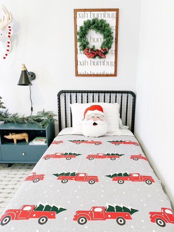 a wreath artwork, some faux fir garlands, bright printed bedding for creating a holiday feel in the space easily