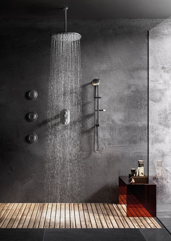 a concrete shower space with a wooden floor, a glass wall and a dark glass mini bench is a cozy and cool space