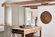a contemporary neutral kitchen in white and dove grey, a wooden kitchen island, wooden beams for a welcoming feel