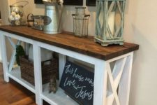 a farmhouse console with a rich stained tabletop, a chalkboard sign, a cotton branch arrangement and a gallery wall