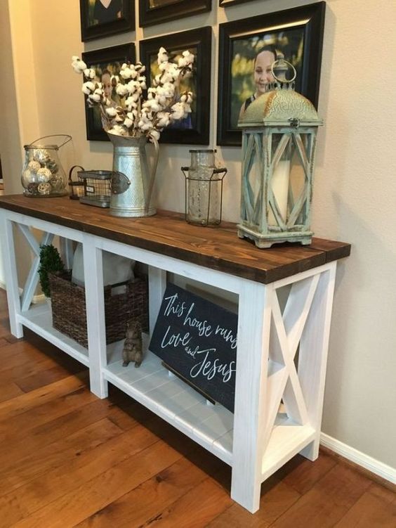 a farmhouse console with a rich stained tabletop, a chalkboard sign, a cotton branch arrangement and a gallery wall