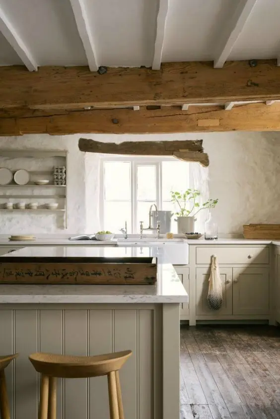 a rustic English country kitchen in light grey, white textural walls, wooden beams on the ceiling for a cozy feel