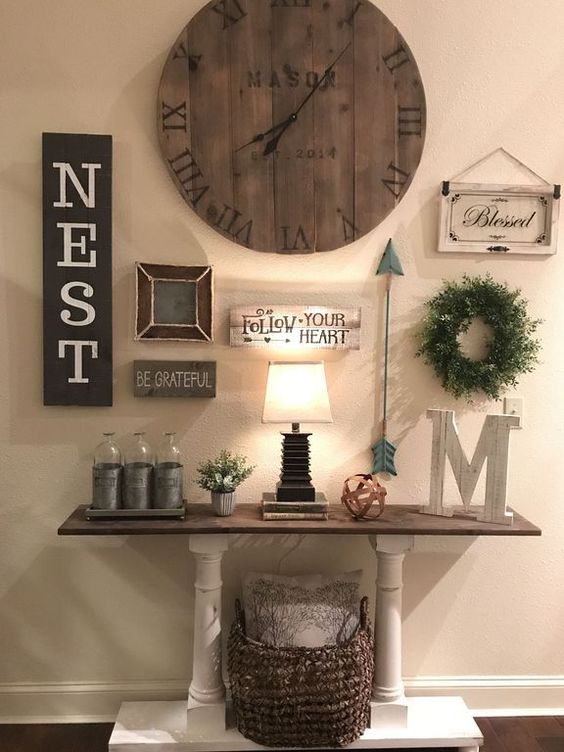 a vintage farmhouse console with a basket for storage, a gallery wall with signs and a large clock