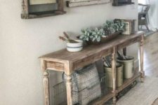 a vintage meets farmhouse entryway with a wooden console, vintage posters as artworks and some jute integrated