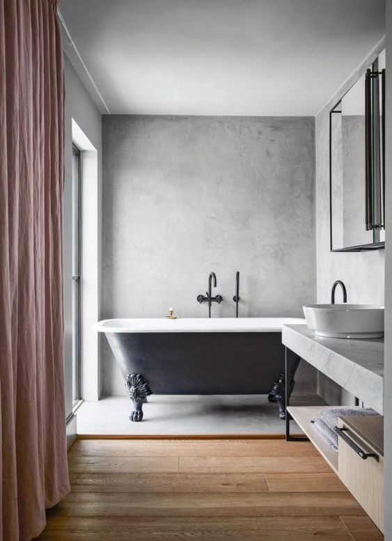 an eclectic bathroom with concrete walls and a floor, a wooden floor and a concrete vanity, a large mirror and a window