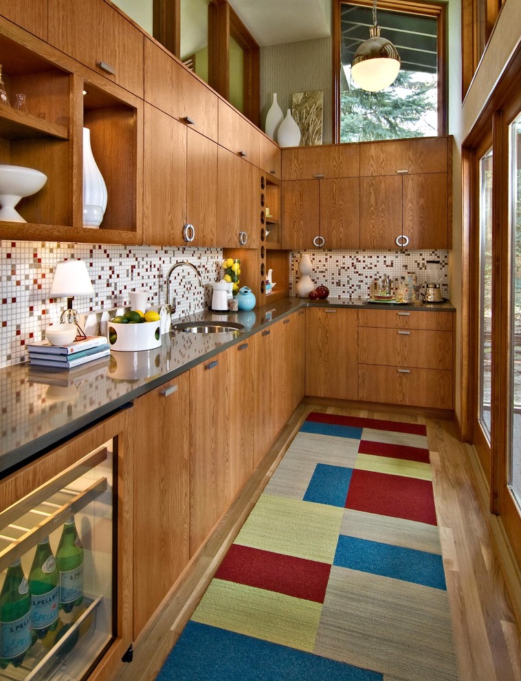 a rich colored wooden kitchen with a mosaic tile backsplash, a color block rug and much natural wood  (Design By Lisa)