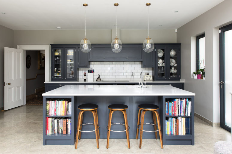 a grey mid-century modern kitchen with graphite cabinets, a large kitchen island with a white countertop and pendant lamps  (The Shaker Kitchen Company)