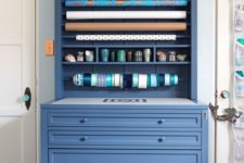 a blue storage piece with drawers and fabric basket and some open shelving