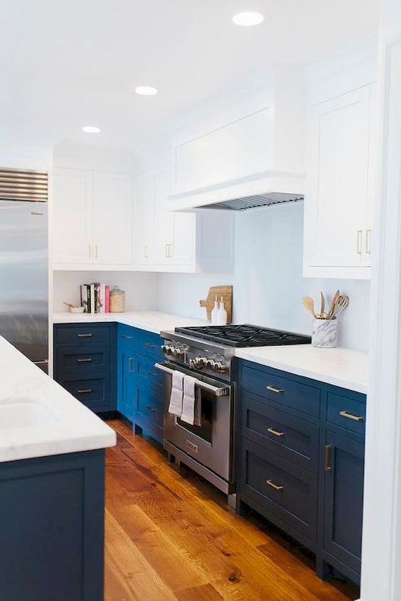 a bold blue and white mid-century modern kitchen with white countertops and a metal cooker
