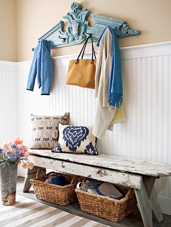 a bright shabby chic entryway with white shiplap, a wooden bench, baskets, pillows and a blue clothes hanger