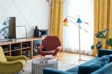 a colorful living room with a stained storage unit, a navy velvet sofa, a striped coffee table, colorful chairs, a bright floor lamp and a paneled wall