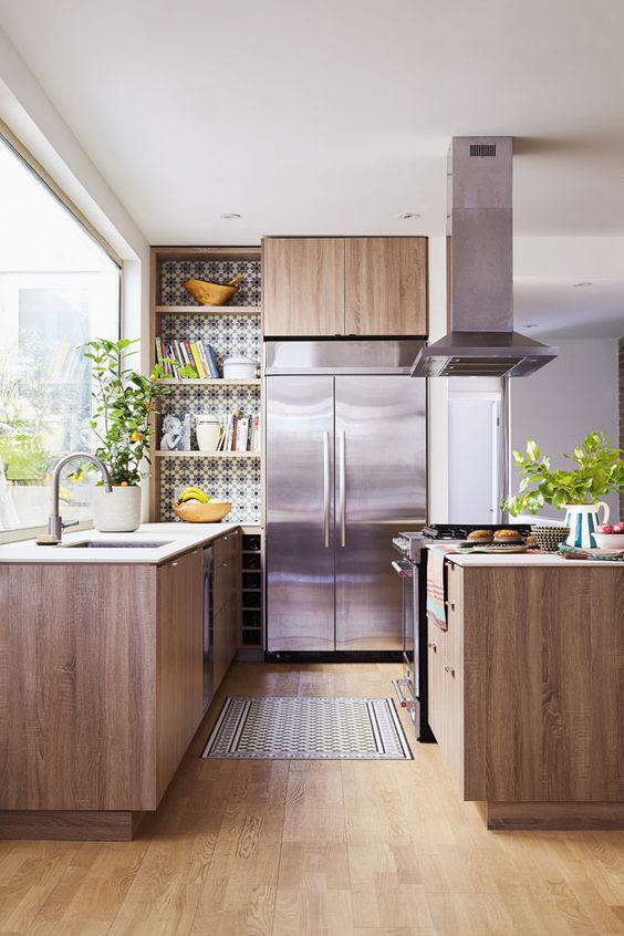 a cozy mid-century modern kitchen with mosaic tiles, wooden cabinets and metal appliances