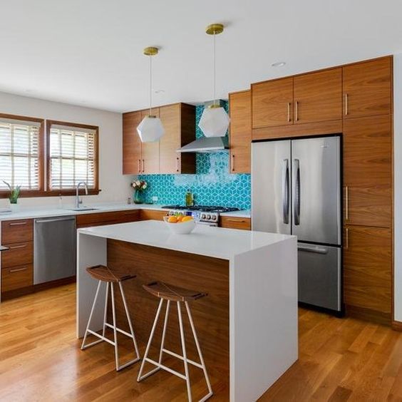 a cozy yet small mid-century modern kitchen with rich-stained cabinets, a turquoise tile backsplash, pendant lamps and a kitchen island