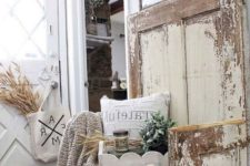 a farmhouse shabby chic entry with signs, a wooden bench, wheat, greenery and a knit blanket