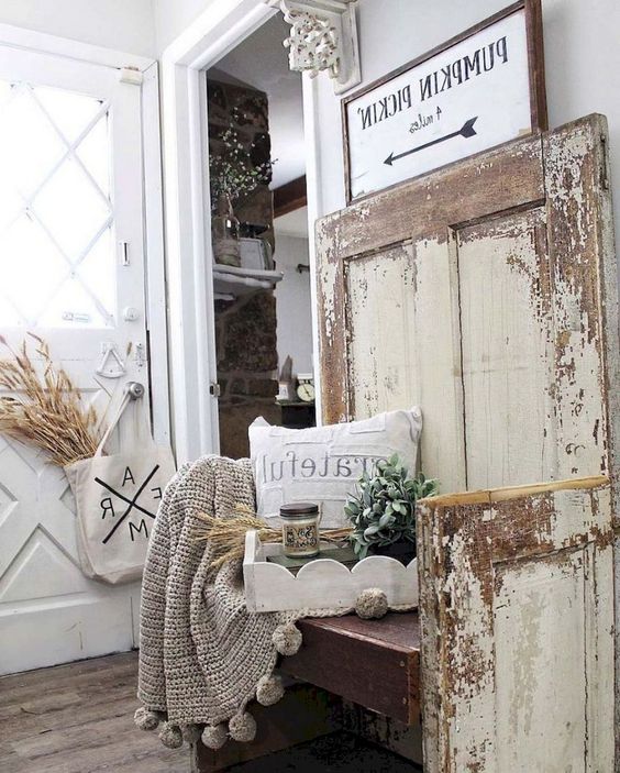 a farmhouse shabby chic entry with signs, a wooden bench, wheat, greenery and a knit blanket