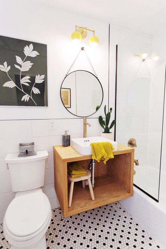 a gorgeous monochromatic bathroom with penny tiles and a floating vanity plus touches of mustard to make it bright